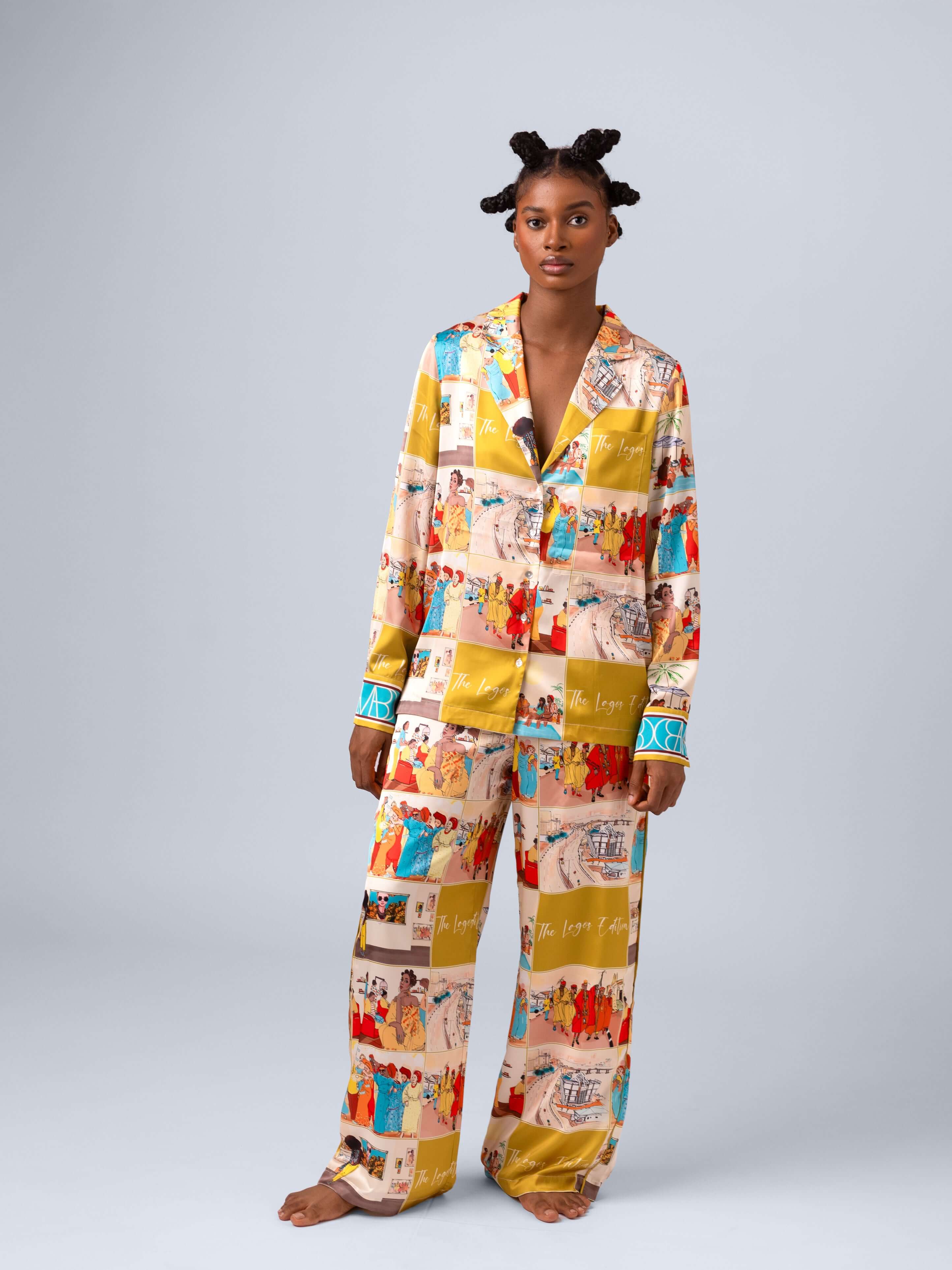 Model wearing vibrant printed pajama set featuring colorful scenes and stylish details.