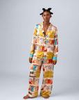 Model wearing vibrant printed pajama set featuring colorful scenes and stylish details.